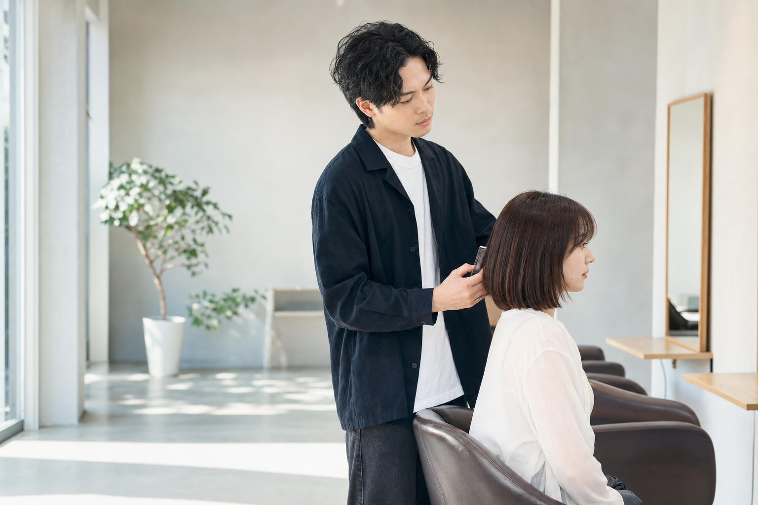 明るいサロンで髪を丁寧に施術している手元